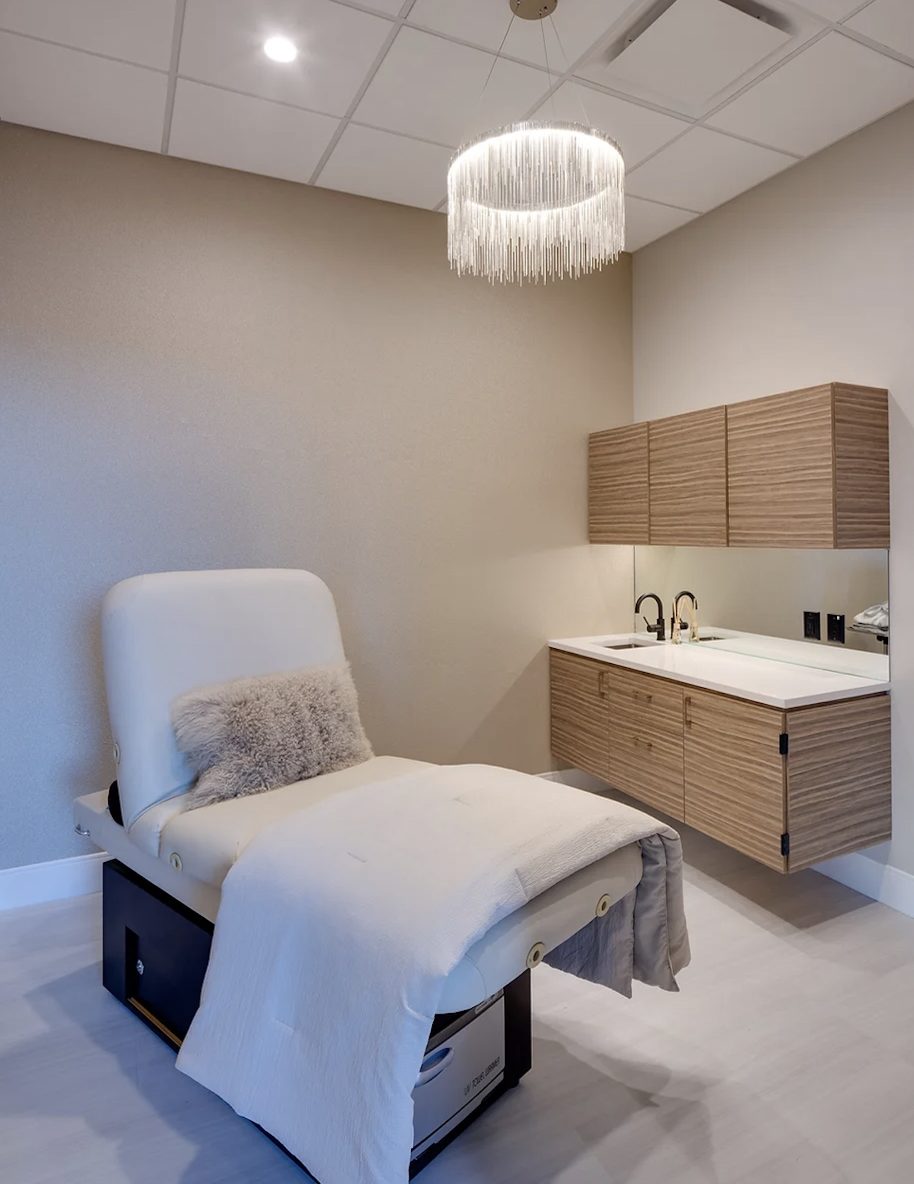 Treatment room at Skin & Body 101, lit by a soft overhead chandelier